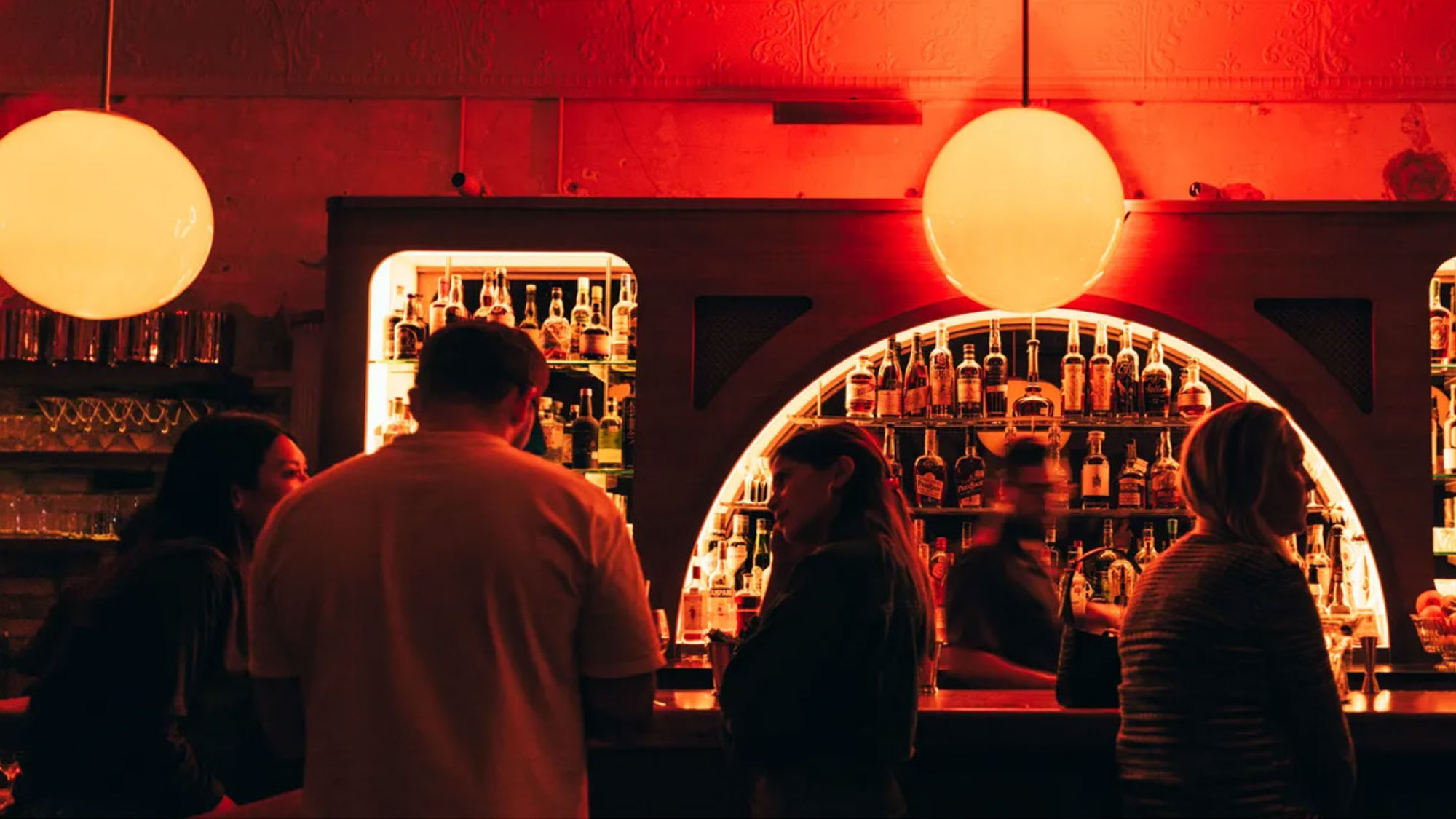 A late night bar with glowing red lights and special drinks